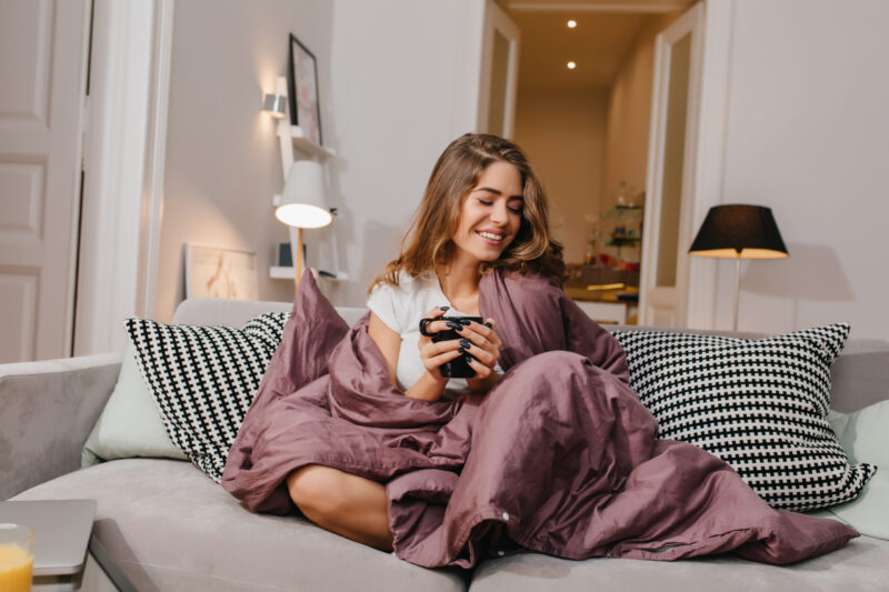 woman on couch with weighted blanket