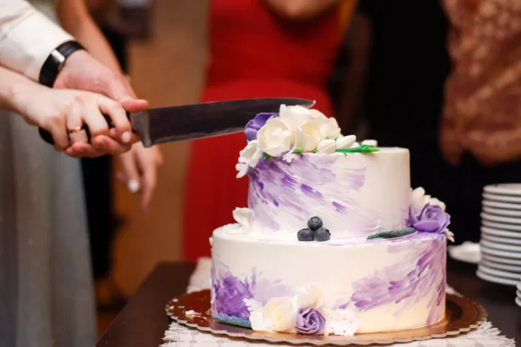 white wedding cake being sliced