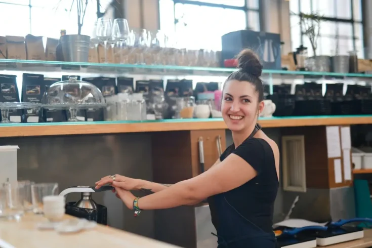 cheerful female bartender preparing drink