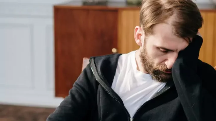 man in black zip up jacket sitting on chair