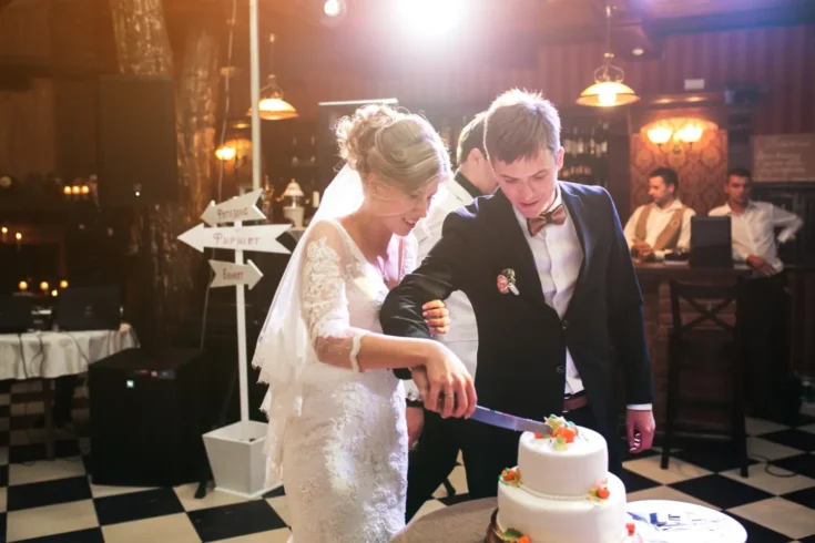 bride and groom slicing wedding cake